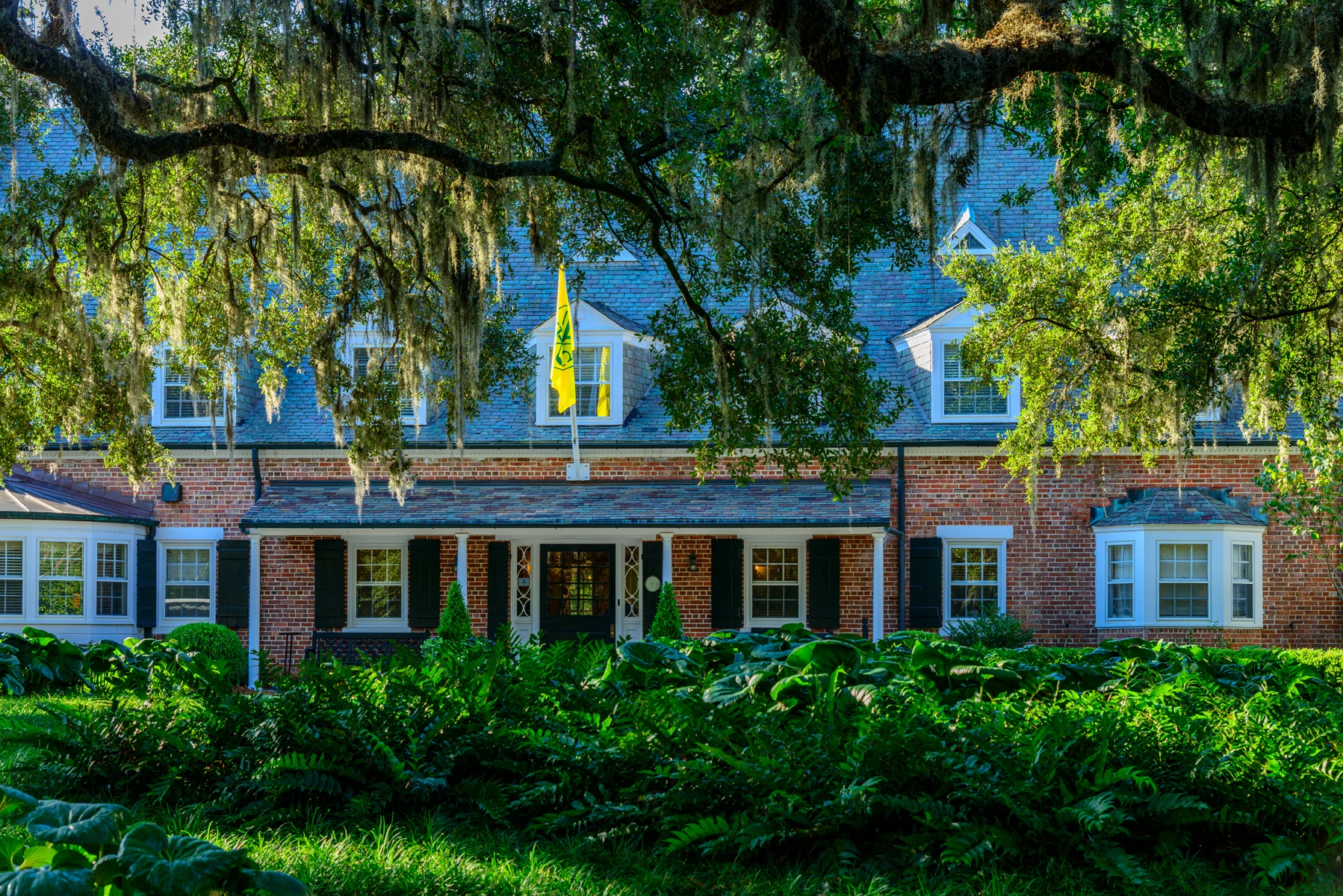 Spanish moss frames the brick entrance to Yeamans Hall Club